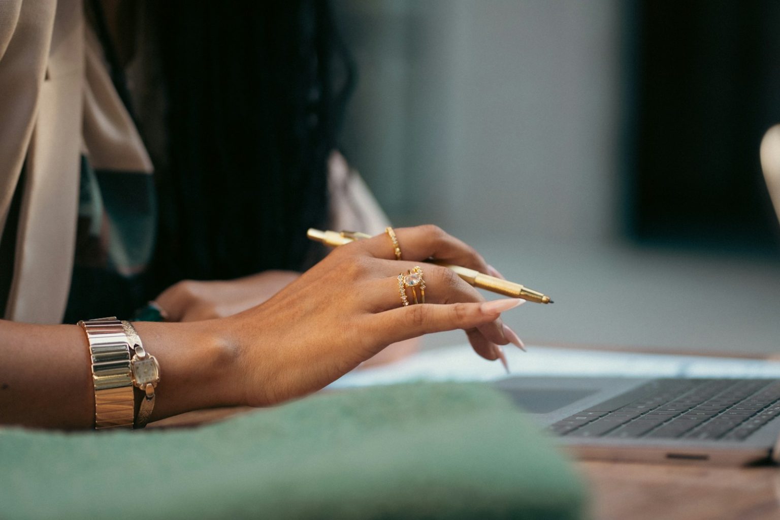 A woman sitting at a table with a laptop computer; business plan examples